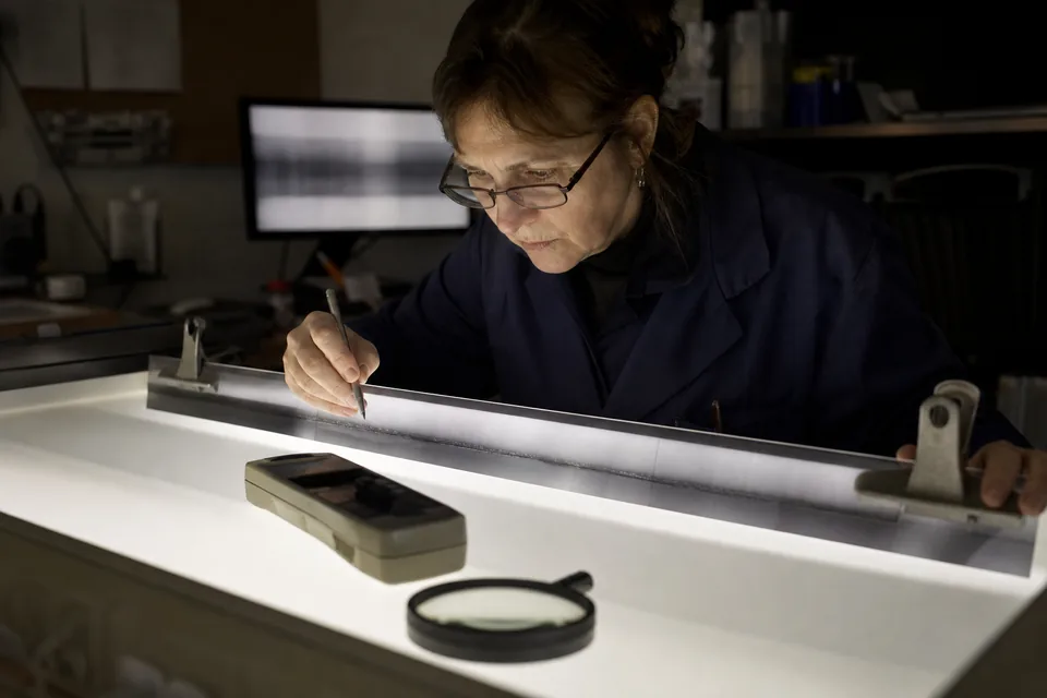 An inspector reading a weld radiograph on a light screen with a densitometer in hand